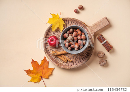 Autumn flat lay with bright colorful maple leaves  with apple and nuts on wooden cutting board 116434782