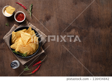 Traditional Mexican corn chips nachos with salsa and cream sauce, herbs, salt and chili pepper Traditional Mexican corn chips nachos with salsa and cream sauce, herbs, salt and chili pepper 116434842