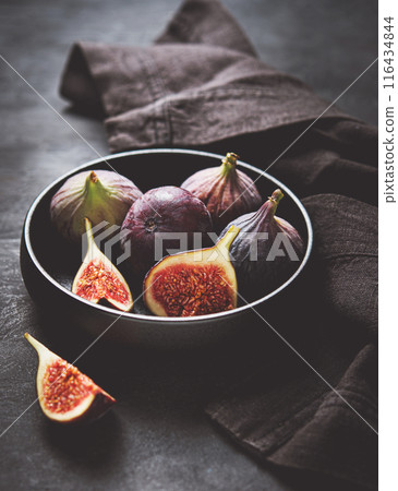 Fresh ripe figs in a black bowl on a dark gray background close-up. Dark and mood concept. 116434844