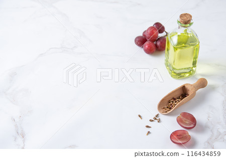 natural dietary and vegan grape seed oil in glass bottles on a white marble background. natural dietary and vegan grape seed oil in glass bottles on a white marble background. 116434859