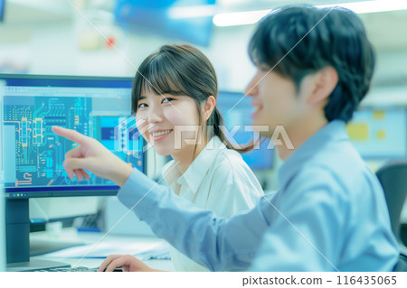 Male and female engineers working on CAD design of circuit boards_1 Male and female engineers working on CAD design of circuit boards_1 116435065