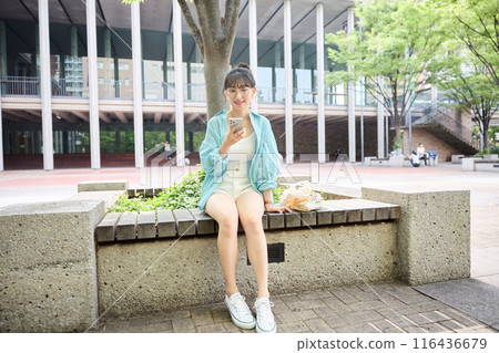 女大學生在長椅上看智慧型手機 女大學生在長椅上看智慧型手機 116436679