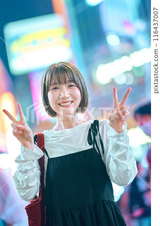 Young woman enjoying the downtown area at night 116437007