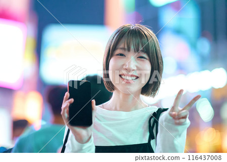 Young woman enjoying the downtown area at night 116437008