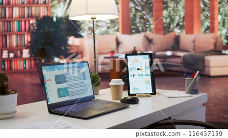 Empty home office with tablet and laptop showing infographics and accounting data, financial business reports. Space used for a specialist to study the market and work on economy analysis. Empty home office with tablet and laptop showing infographics and accounting data, financial business reports. Space used for a specialist to study the market and work on economy analysis. 116437159
