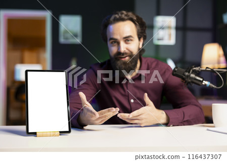 Tech specialist presenting mockup tablet to interested viewers, filming with professional mic. Man reviewing isolated screen digital device, recording with specialized equipment 116437307