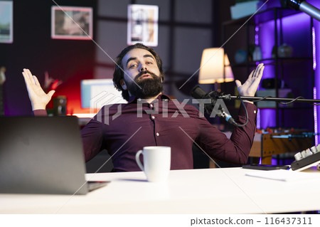 Content creator shooting apology video for disappointed fans, doing shrugging shoulders gesturing. Influencer throwing hands up in air, apologizing and admitting mistakes 116437311