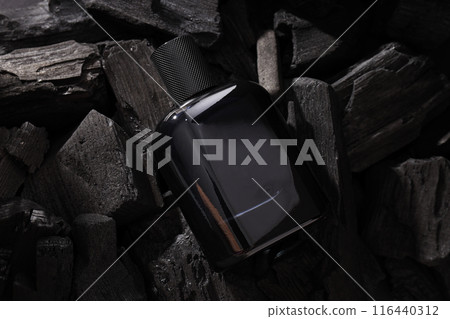 Black bottle with men's perfume on dark background, close up Black bottle with men's perfume on dark background, close up 116440312