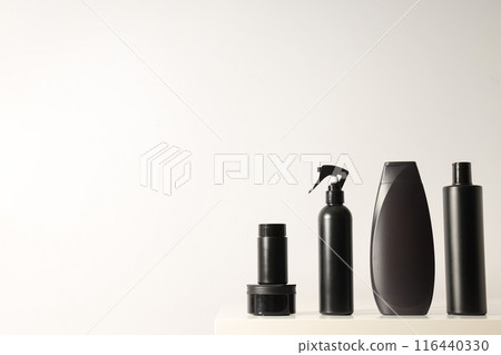 Black cosmetics bottles and jar on white background, space for text 116440330