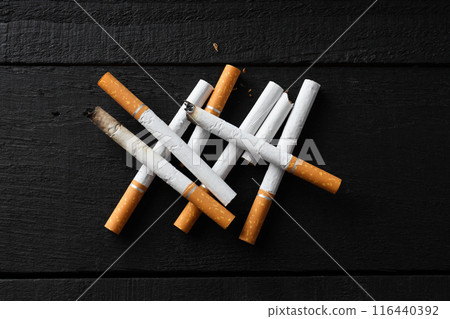 Cigarettes lie on a dark wooden background Cigarettes lie on a dark wooden background 116440392
