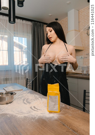 Woman Standing in Kitchen Next to Table 116441025