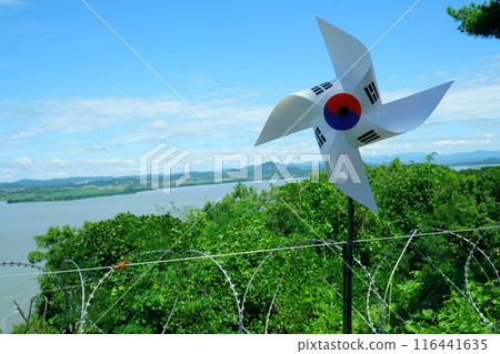 Behind the pinwheel and barbed wire with the Korean national flag engraved on it, across the river into North KoreaNorth Korea across the river 116441635