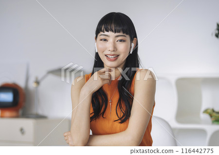戴著耳機微笑的年輕女子看著鏡頭說話 116442775