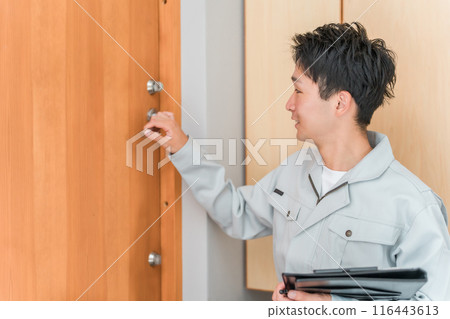 建築公司/房屋建築商的一名男工人檢查前門 116443613