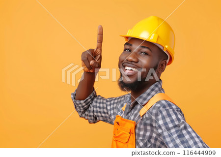 African American Repairman Pointing Upwards Against Yellow Background African American Repairman Pointing Upwards Against Yellow Background 116444909
