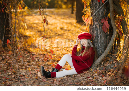 Happy child Caucasian girl sitting near a tree in the park on a sunny day Happy child Caucasian girl sitting near a tree in the park on a sunny day 116444939