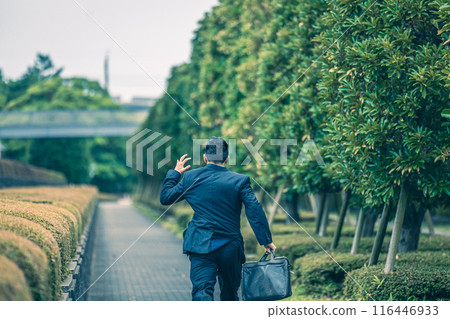 A middle-aged businessman in a suit running through the city A middle-aged businessman in a suit running through the city 116446933