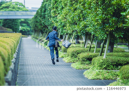 A middle-aged businessman in a suit running through the city A middle-aged businessman in a suit running through the city 116446973