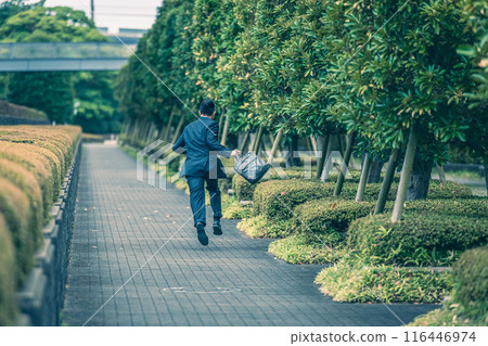 A middle-aged businessman in a suit running through the city A middle-aged businessman in a suit running through the city 116446974