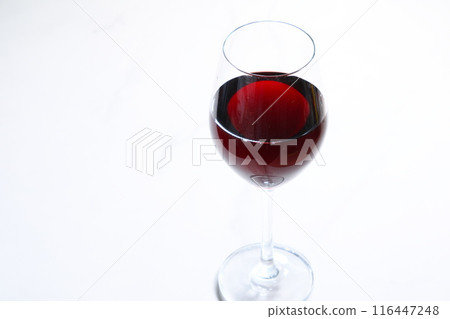 A blissful moment to slowly savor delicious red wine poured into a wine glass 116447248