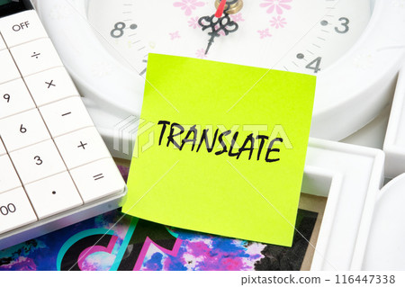 TRANSLATE word written on a light green sticker on the background of a clock near the calculator TRANSLATE word written on a light green sticker on the background of a clock near the calculator 116447338