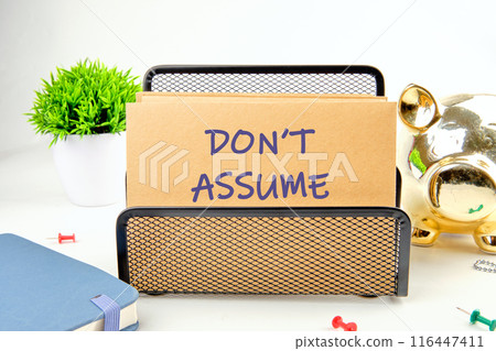 DO NOT ASSUME text on a postal envelope in a stand on a white background DO NOT ASSUME text on a postal envelope in a stand on a white background 116447411