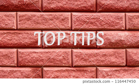 Conceptual symbol TOP TIPS. Copy space. Top tips words written on a red decorative brick 116447450