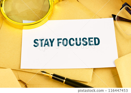 STAY FOCUSED text on a white business card lying on postal envelopes 116447453