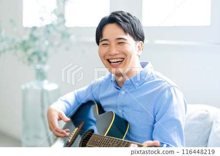 彈吉他的一個年輕人 116448219