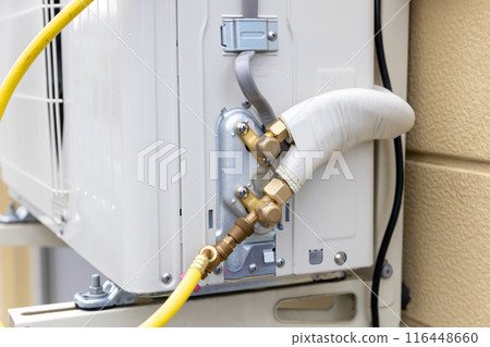 Vacuuming the outdoor unit of a home air conditioner Vacuuming the outdoor unit of a home air conditioner 116448660