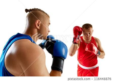 Two combat athletes engaged in sparring session, red competitor against blue competitor against white studio background. Two combat athletes engaged in sparring session, red competitor against blue competitor against white studio background. 116448876