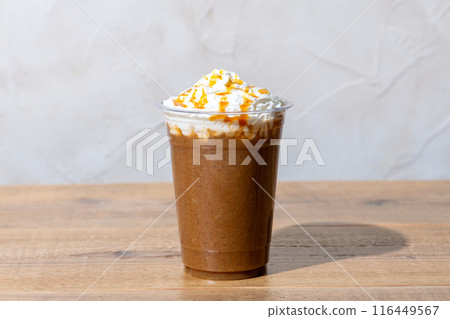 Caramel frappe in a plastic cup on a wooden table 116449567