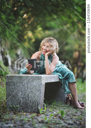 Woman reads a cheerful story from ebook Woman reads a cheerful story from ebook 116450694