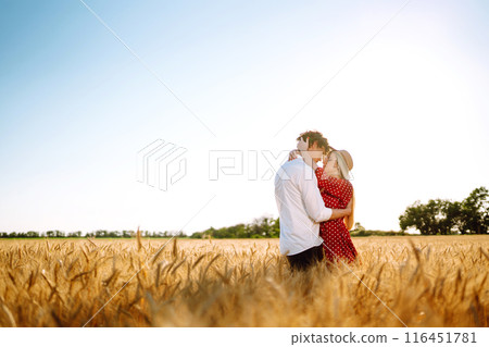 Young happy couple hugging on a wheat field, on the sunset. Enjoying time together. Young happy couple hugging on a wheat field, on the sunset. Enjoying time together. 116451781