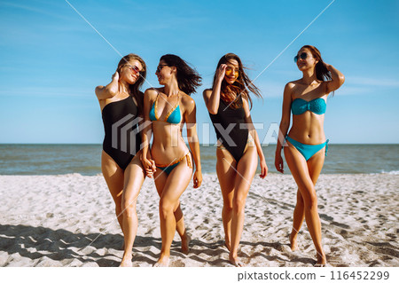 Happy four girls strolling along a beach. Young women enjoying on beach holiday. Summer, relax. Happy four girls strolling along a beach. Young women enjoying on beach holiday. Summer, relax. 116452299