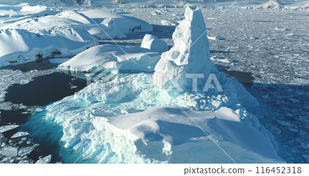 Arctic landscape. Snow covered icebergs melt at turquoise ocean icy bay. Huge ice glacier at polar nature environment. Antarctica winter landscape at global warming problem. Aerial view panorama 116452318