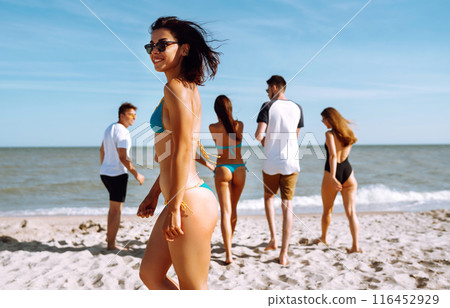 Group of friends having fun and running along beach. Young friends enjoying on beach holiday. Summertime Group of friends having fun and running along beach. Young friends enjoying on beach holiday. Summertime 116452929