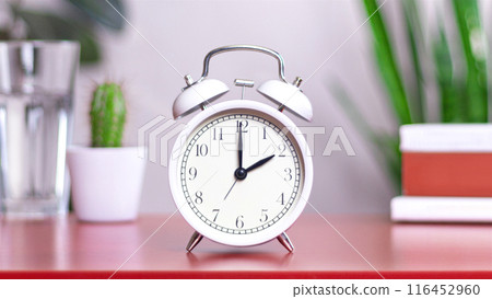 Classic white clock on a table. The clock hand points at 2, 14 close up photo interior 116452960