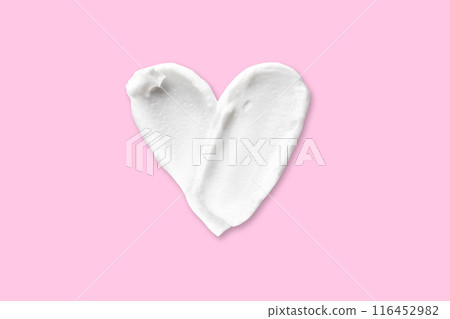 Swatch Smear of cosmetic white cream in the shape of a heart isolated on a pink background. close up 116452982
