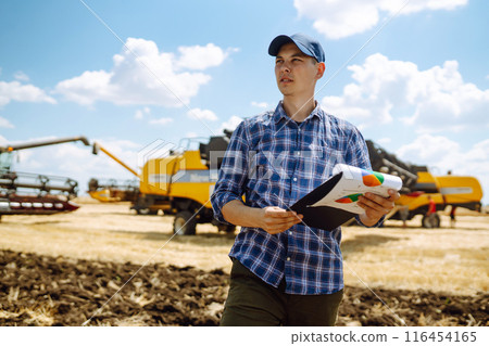 Farmer holds tablet with yield map for combine in wheat field. Precision farming Agriculture concept 116454165