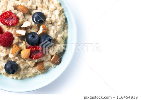 Oatmeal porridge with raspberries, blueberries and almonds in bowl isolated on white background Oatmeal porridge with raspberries, blueberries and almonds in bowl isolated on white background 116454919