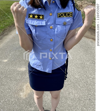 A female police officer pumps her fist in the air. 116455007