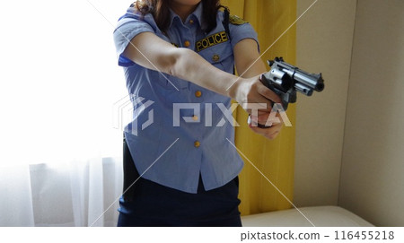 Female police officer holding a pistol Female police officer holding a pistol 116455218