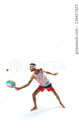 Young focused man, beach tennis player with colorful racket, playing isolated on white background 116457825