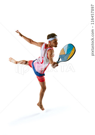 Focused man in colorful sportswear, beach tennis player in motion, hitting with racket, training isolated on white background Focused man in colorful sportswear, beach tennis player in motion, hitting with racket, training isolated on white background 116457897