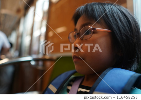 A child riding a train alone and feeling nervous 116458253