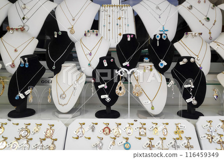 Necklaces and pendants on display in the window of a jewelry store Necklaces and pendants on display in the window of a jewelry store 116459349