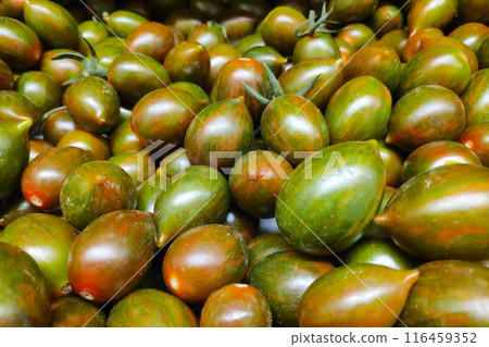 Stack of Tomato crispino plums on a market stall Stack of Tomato crispino plums on a market stall 116459352