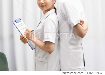 Smiling Asian male and female medical workers in white coats Smiling Asian male and female medical workers in white coats 116459937