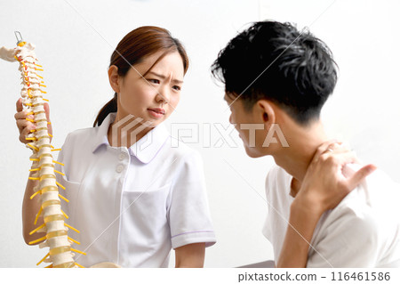 女醫師用骨頭模型向男患者解釋 女醫師用骨頭模型向男患者解釋 116461586